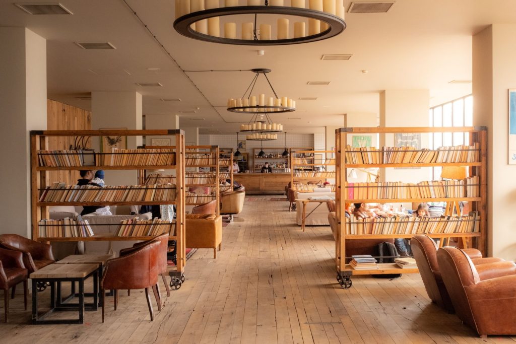 Warm and inviting library interior in Stepantsminda, Georgia with wooden bookshelves and leather chairs.